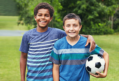 Buy stock photo Shot of two young boys out for a game of soccer in the park