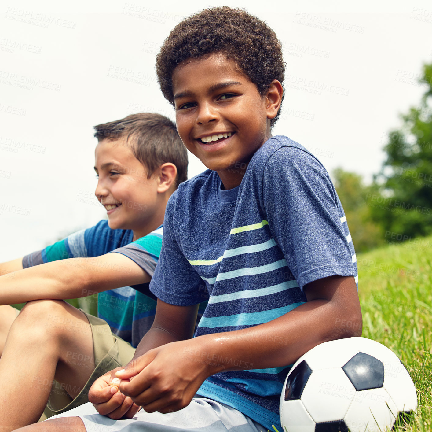 Buy stock photo Portrait, boy and sitting on grass with soccer ball in park for happiness, development or freedom in morning. Outdoor, nature and child with friends for break, youth or relax on weekend in Florida