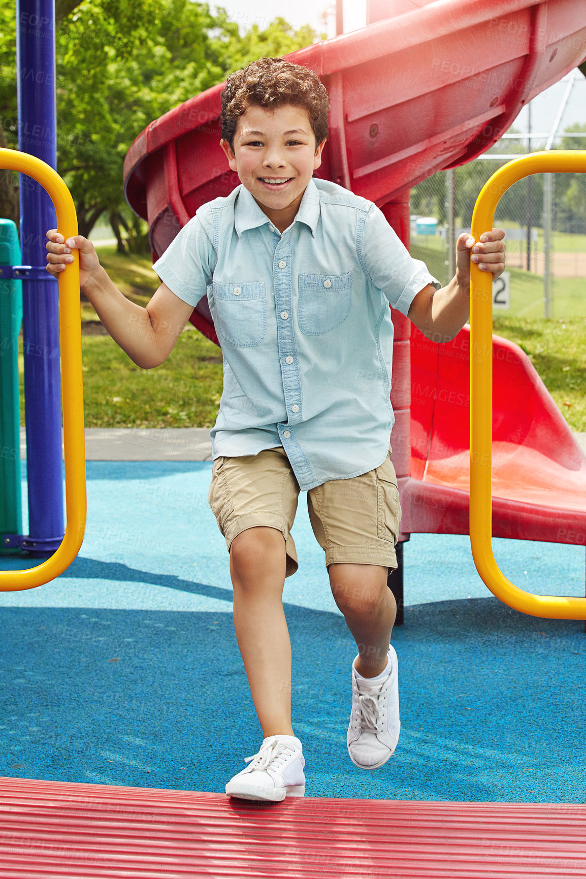 Buy stock photo Shot of a young boy playing on the jungle gym in the park