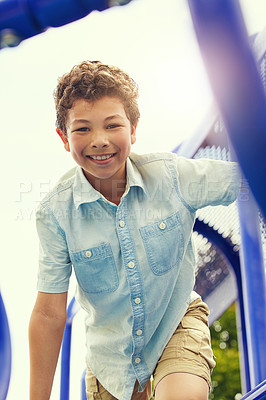 Buy stock photo Shot of a young boy playing on the jungle gym in the park