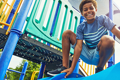 Buy stock photo Shot of a young boy playing on the jungle gym in the park