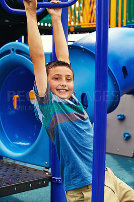 Buy stock photo Shot of a young boy playing on the jungle gym in the park