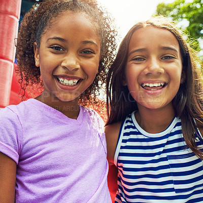 Buy stock photo Shot of two young friends hanging out together at a playground