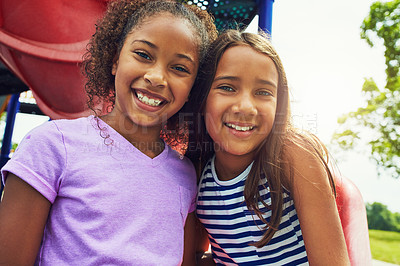 Buy stock photo Shot of two young friends hanging out together at a playground