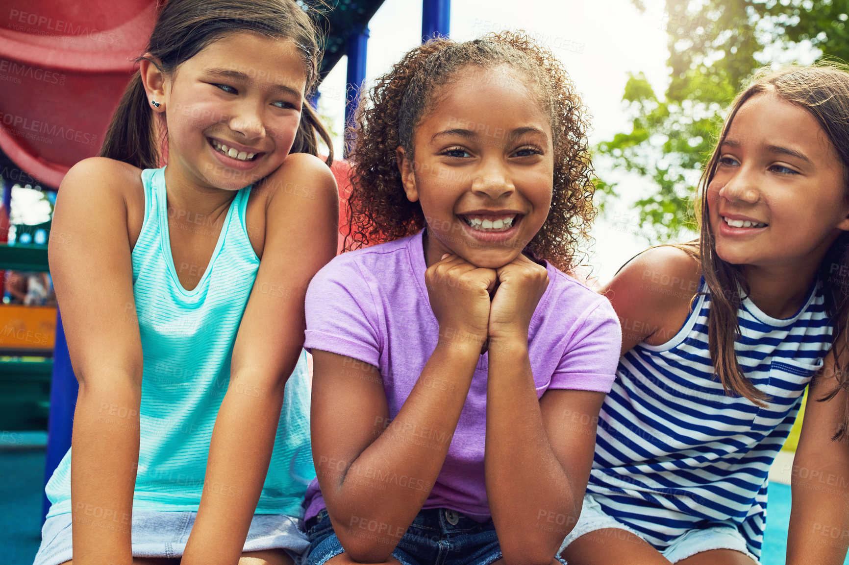 Buy stock photo Shot of a group of young friends hanging out together at a playground