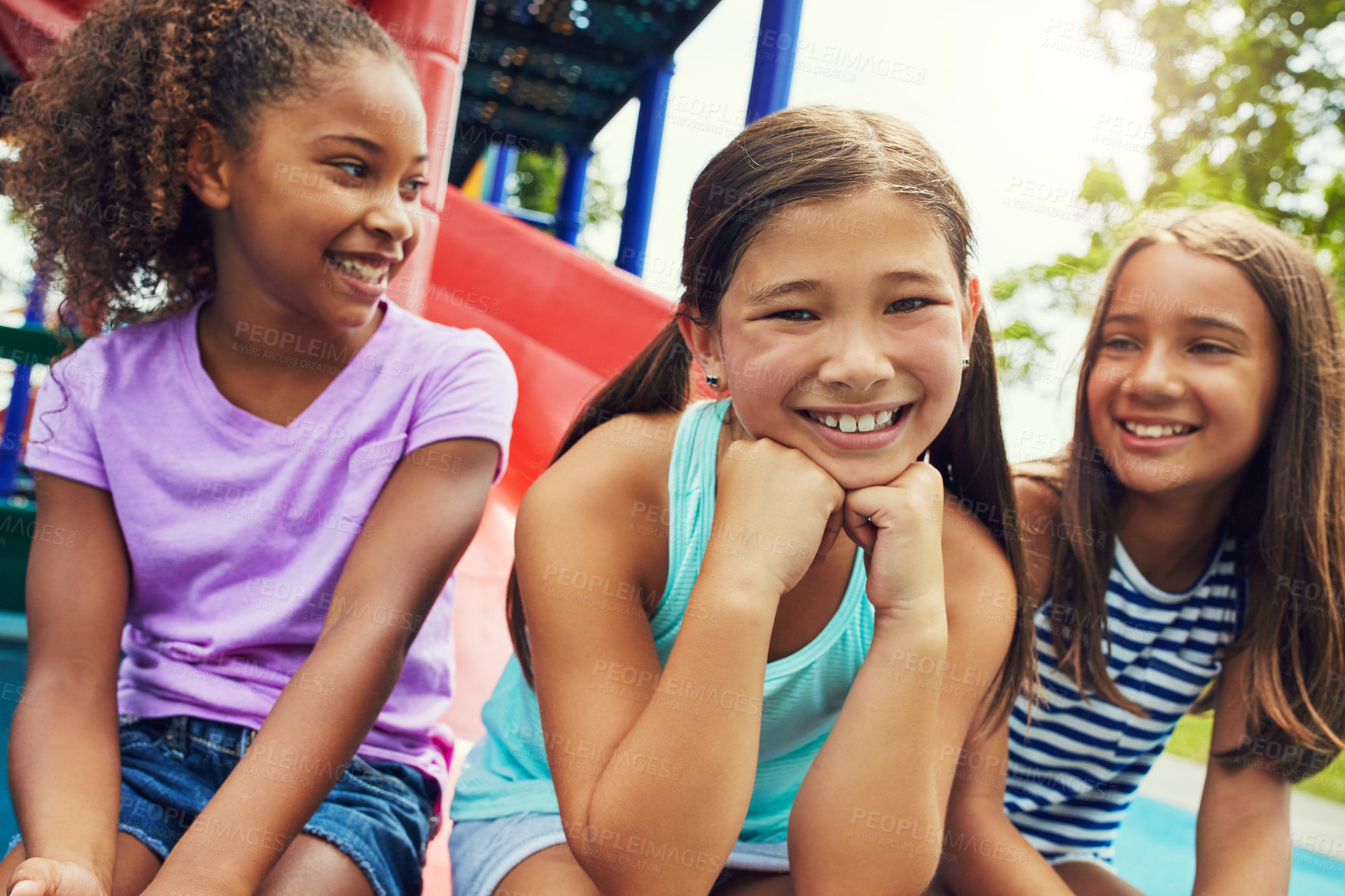 Buy stock photo Shot of a group of young friends hanging out together at a playground