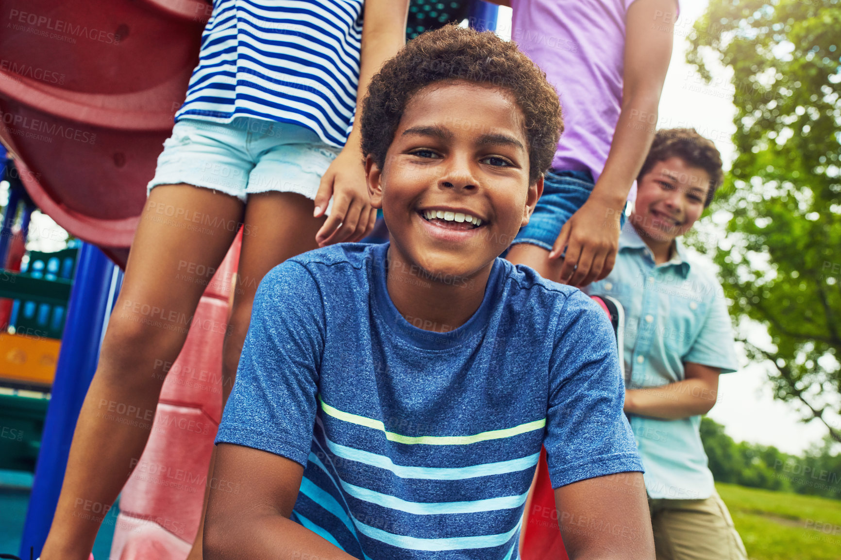 Buy stock photo Shot of a group of young friends hanging out together at a playground