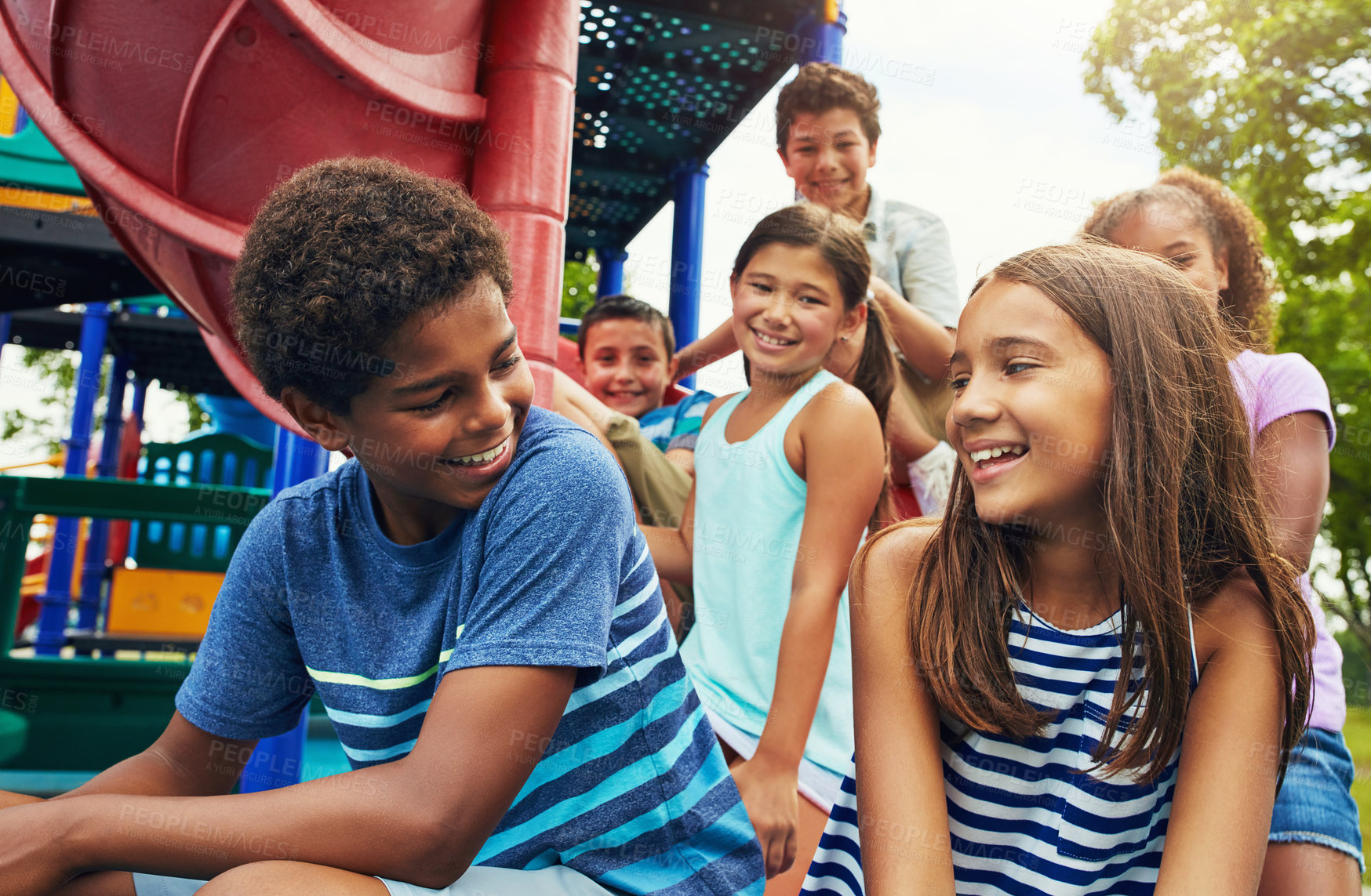 Buy stock photo Shot of a group of young friends hanging out together at a playground