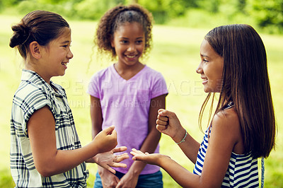 Buy stock photo Shot of adorable little girls playing rock, paper, scissors outdoors