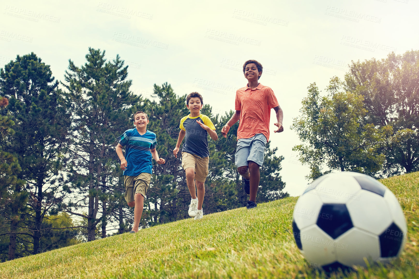 Buy stock photo Shot of young boys playing soccer on a field outdoors