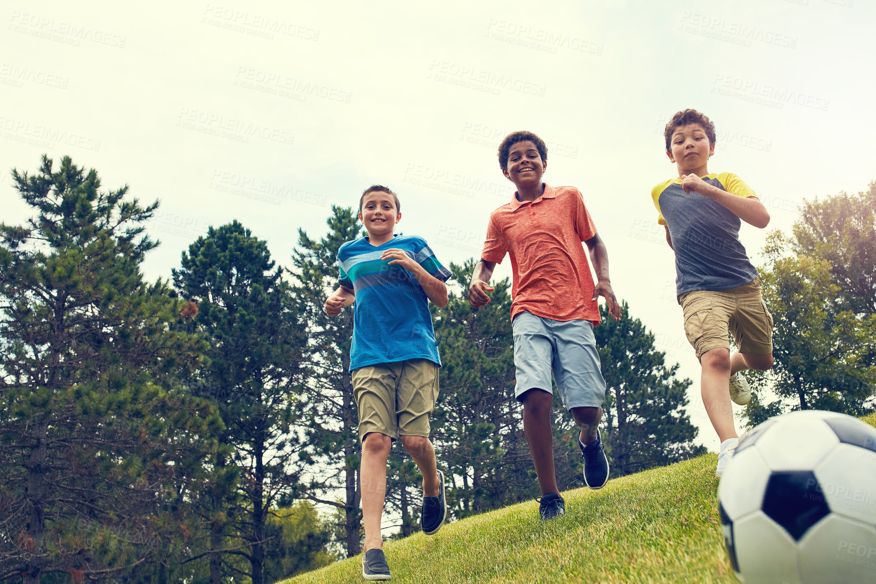 Buy stock photo Soccer, running and children in park for playing, games and fun outdoor holiday together. Sports, kids and happy friends on grass with smile, ball and energy on summer camp for football in garden