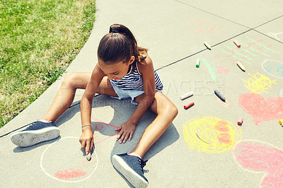 Buy stock photo Shot of an adorable little girl drawing with chalk on the pavement outdoors