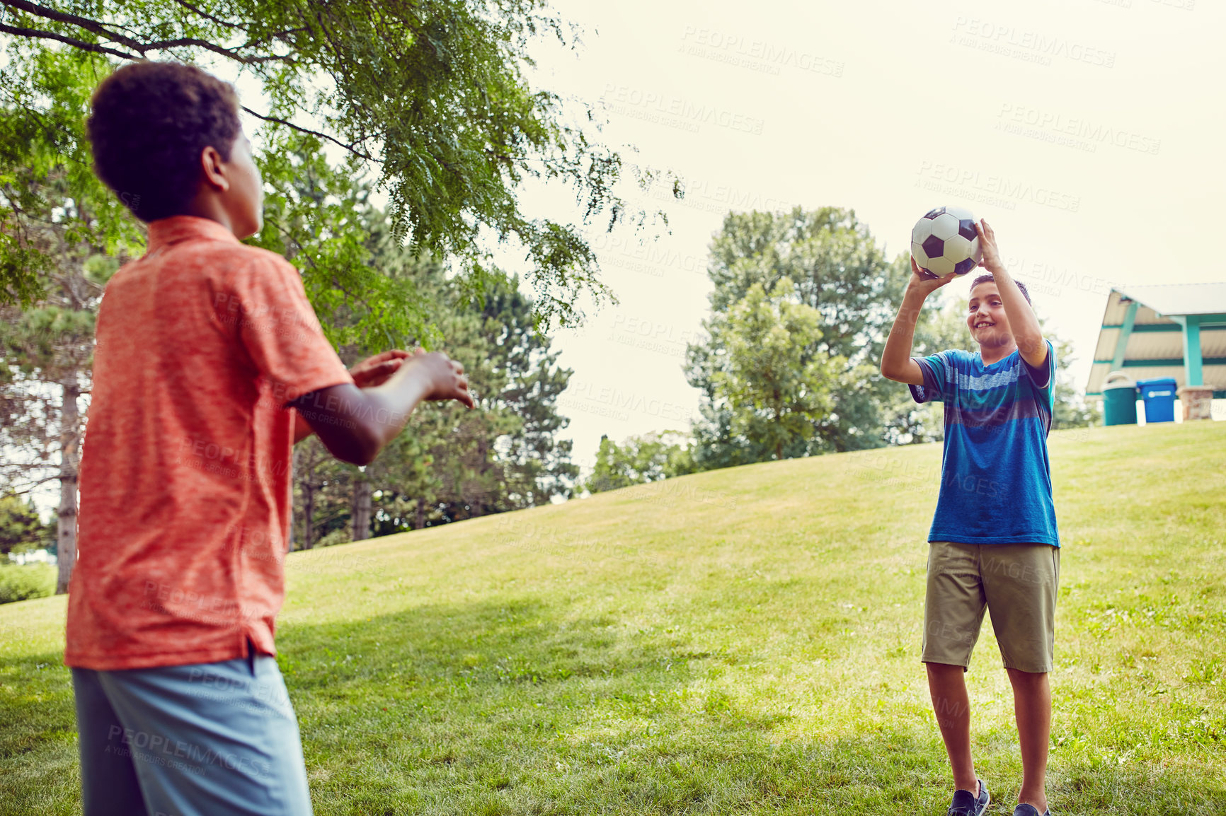 Buy stock photo Throw, catch and children in park with soccer ball for bonding, games and outdoor holiday together. Sports, kids and happy friends on grass with smile, fun and playing on summer camp for football.