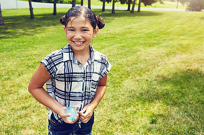 Buy stock photo Shot of an adorable little girl ready to throw balloons outdoors