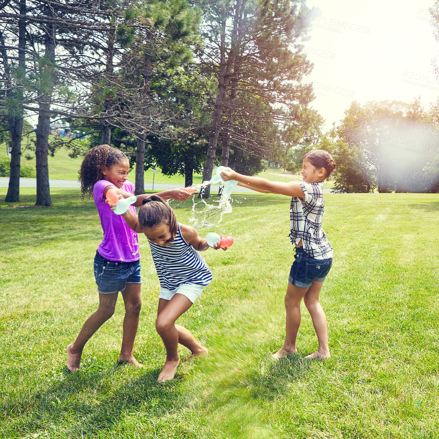 Buy stock photo Shot of adorable little girls playing with water balloons outdoors