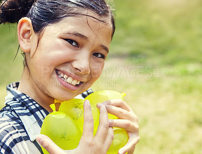 Buy stock photo Portrait of an adorable little girl playing with water balloons outdoors