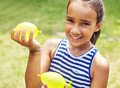 Buy stock photo Portrait of an adorable little girl playing with water balloons outdoors