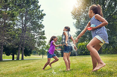 Buy stock photo Shot of adorable little girls playing with water balloons outdoors