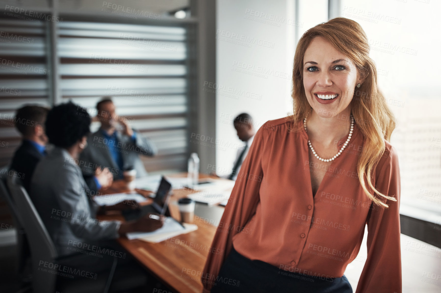 Buy stock photo Portrait of a confident young businesswoman standing in an office with her colleagues in the background