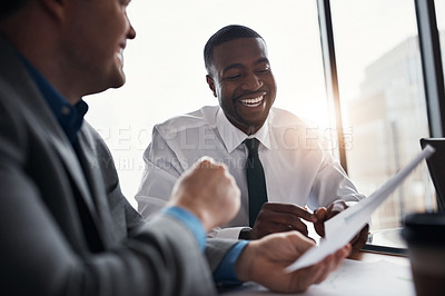 Buy stock photo Shot of two businessmen going through paperwork in an office