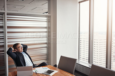 Buy stock photo High angle shot of a handsome businessman sitting with his hands behind his head in his corporate office