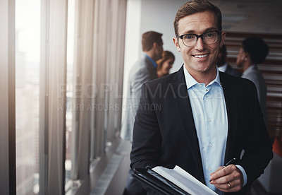 Buy stock photo Portrait of a professional businessman standing in an office with colleagues in the background