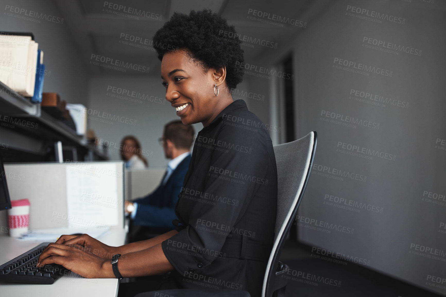 Buy stock photo Shot of a businesswoman sitting at her desk with colleagues in the background