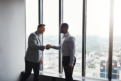 Buy stock photo High angle of two corporate businessmen shaking hands during a meeting in the boardroom