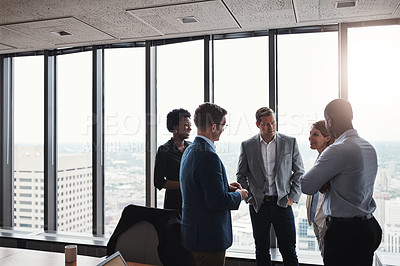 Buy stock photo High angle shot of a group of corporate businesspeople meeting in their boardroom