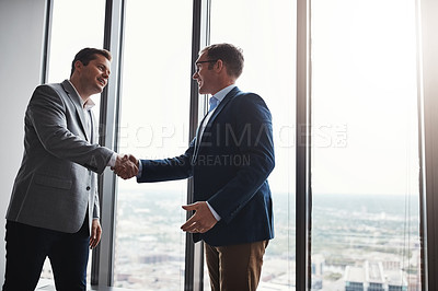 Buy stock photo Low angle shot of two corporate businessmen shaking hands during a meeting in the boardroom