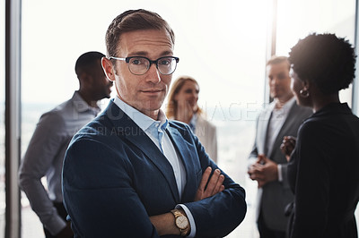 Buy stock photo Cropped portrait of a handsome businessman standing with his arms folded during a meeting in the boardroom