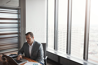 Buy stock photo High angle shot of a handsome businessman working in his corporate office