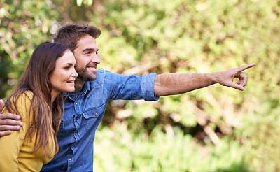 Buy stock photo Happy couple, woman and man pointing in trees or nature for bonding, dating and relationship with smile. People, love and romantic in park or outdoor with joy, excited and commitment in marriage
