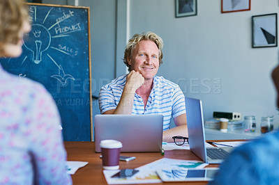 Buy stock photo Portrait of a mature man sitting in on a meeting with his team in a modern office