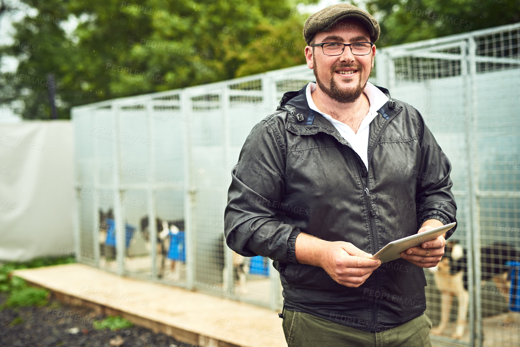 Buy stock photo Happy man, portrait and animal shelter with tablet for care, volunteering or charity on domestic dogs. Young, male person or NGO with smile for pet rescue, rehabilitation centre or adoption in Sweden