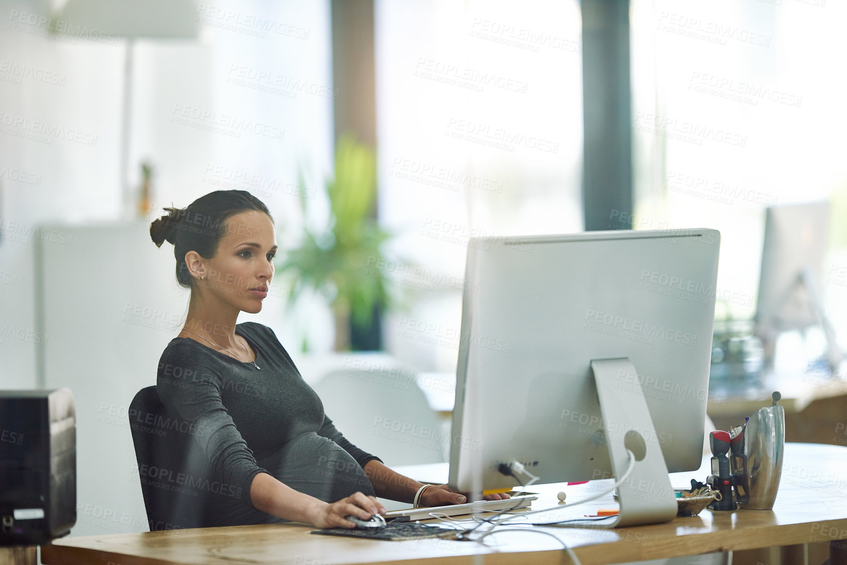 Buy stock photo Cropped shot of a pregnant businesswoman working on her computer in the office