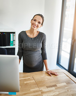Buy stock photo Cropped portrait of a pregnant businesswoman standing at her desk in the office