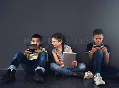 Buy stock photo Kids, friends and serious with technology in studio for connection and educational games on gray background. People, students and smile as elementary school learners on internet for brain development