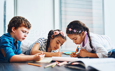 Buy stock photo Cropped shot of kids coloring in while lying on the floor