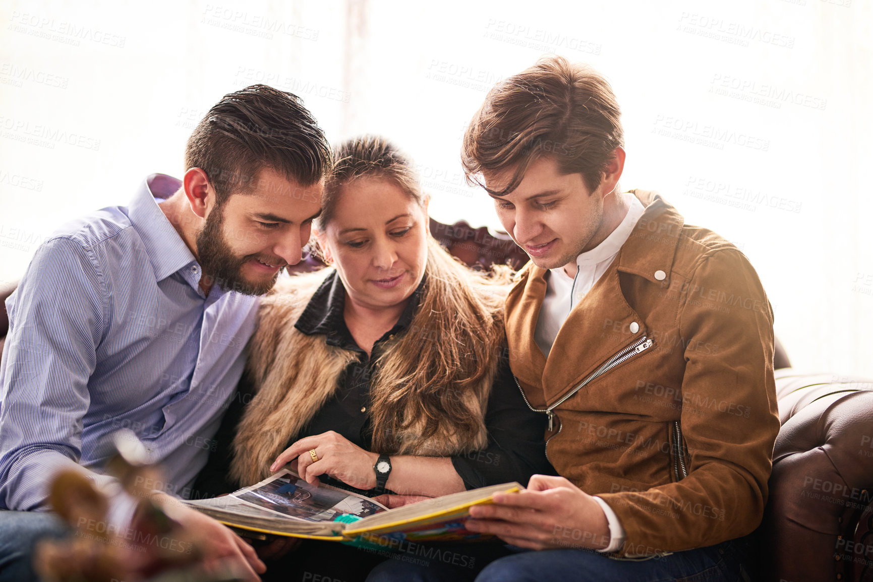 Buy stock photo Cropped shot of a mother and her son's looking at a photo album together at home