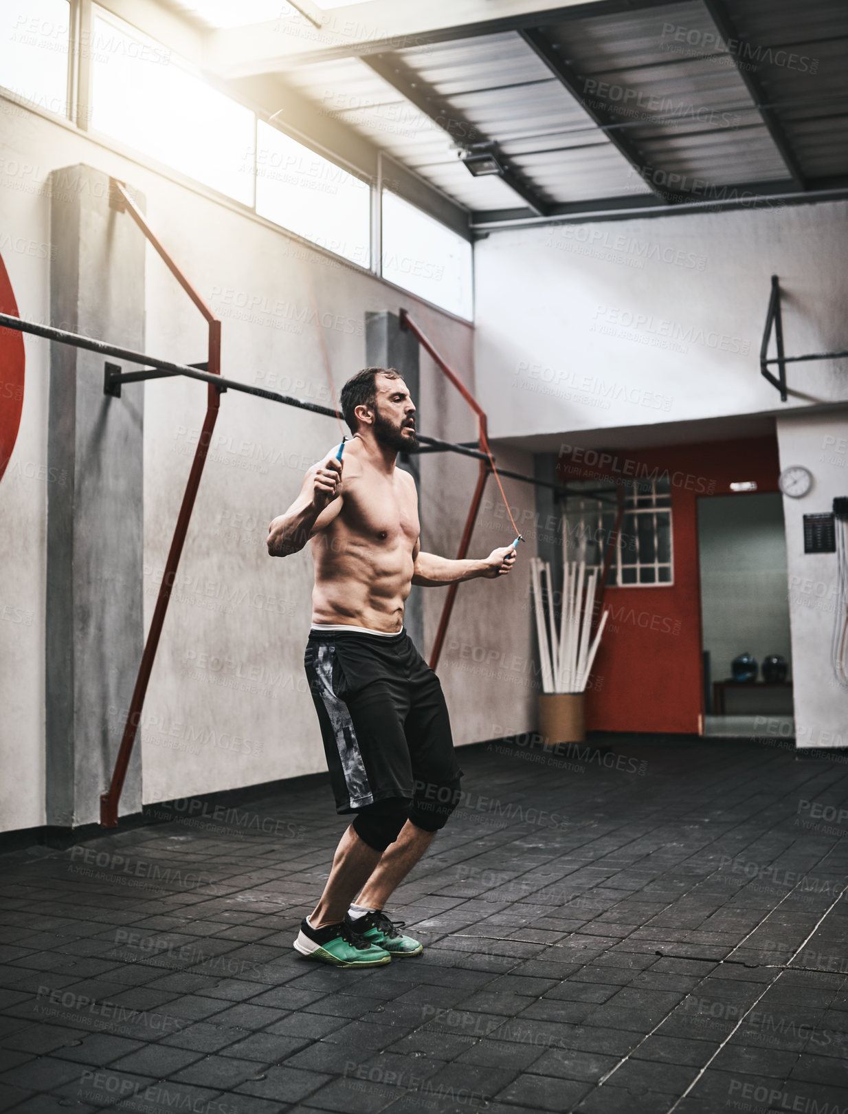 Buy stock photo Shot of a young man skipping rope in a gym