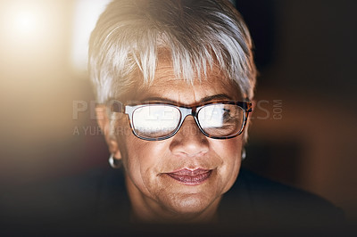 Buy stock photo Shot of a mature businesswoman using a computer during a late night at work