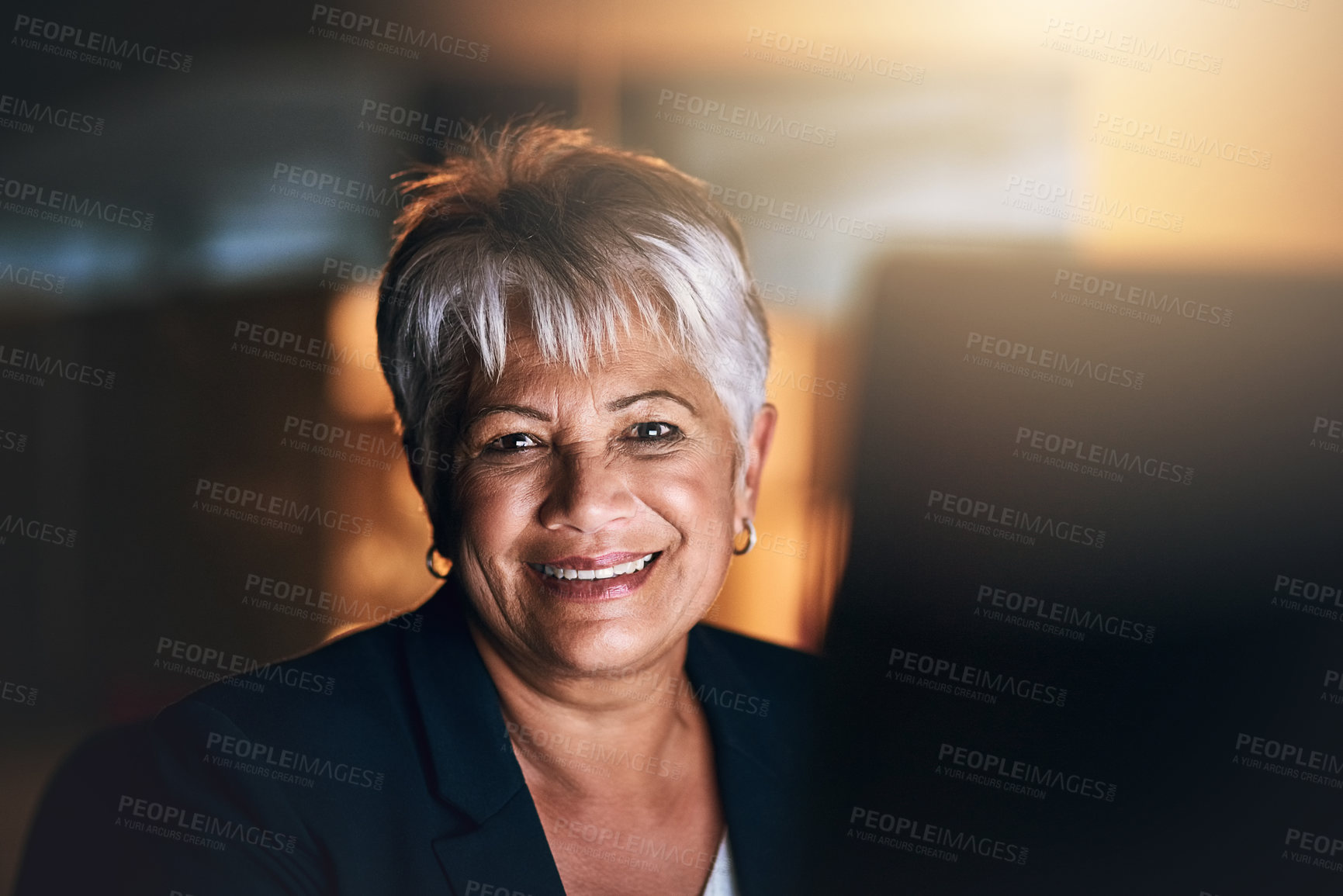 Buy stock photo Shot of a mature businesswoman using a computer during a late night at work