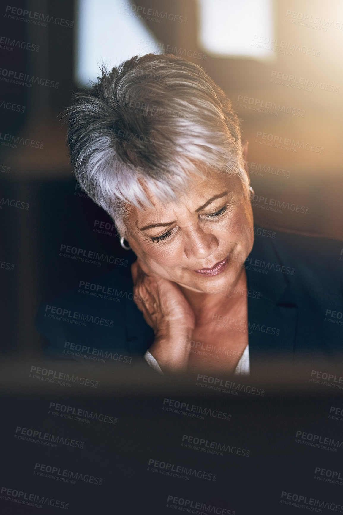 Buy stock photo Shot of a mature businesswoman experiencing strain during a late night at work