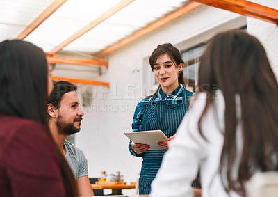 Buy stock photo Shot of a group cheerful  young business colleagues ordering food and drink from a waiter while being seated at a restaurant
