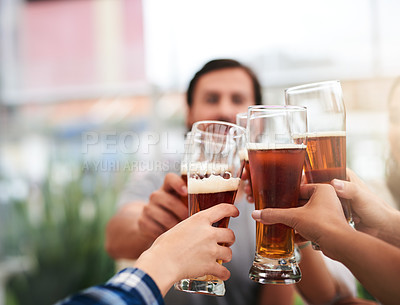 Buy stock photo Shot of a group of young unrecognizable business colleagues having a celebratory toast with beer around a table