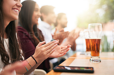 Buy stock photo Shot of a cheerful young group of business work colleagues clapping hands around a table at a restaurant  outside