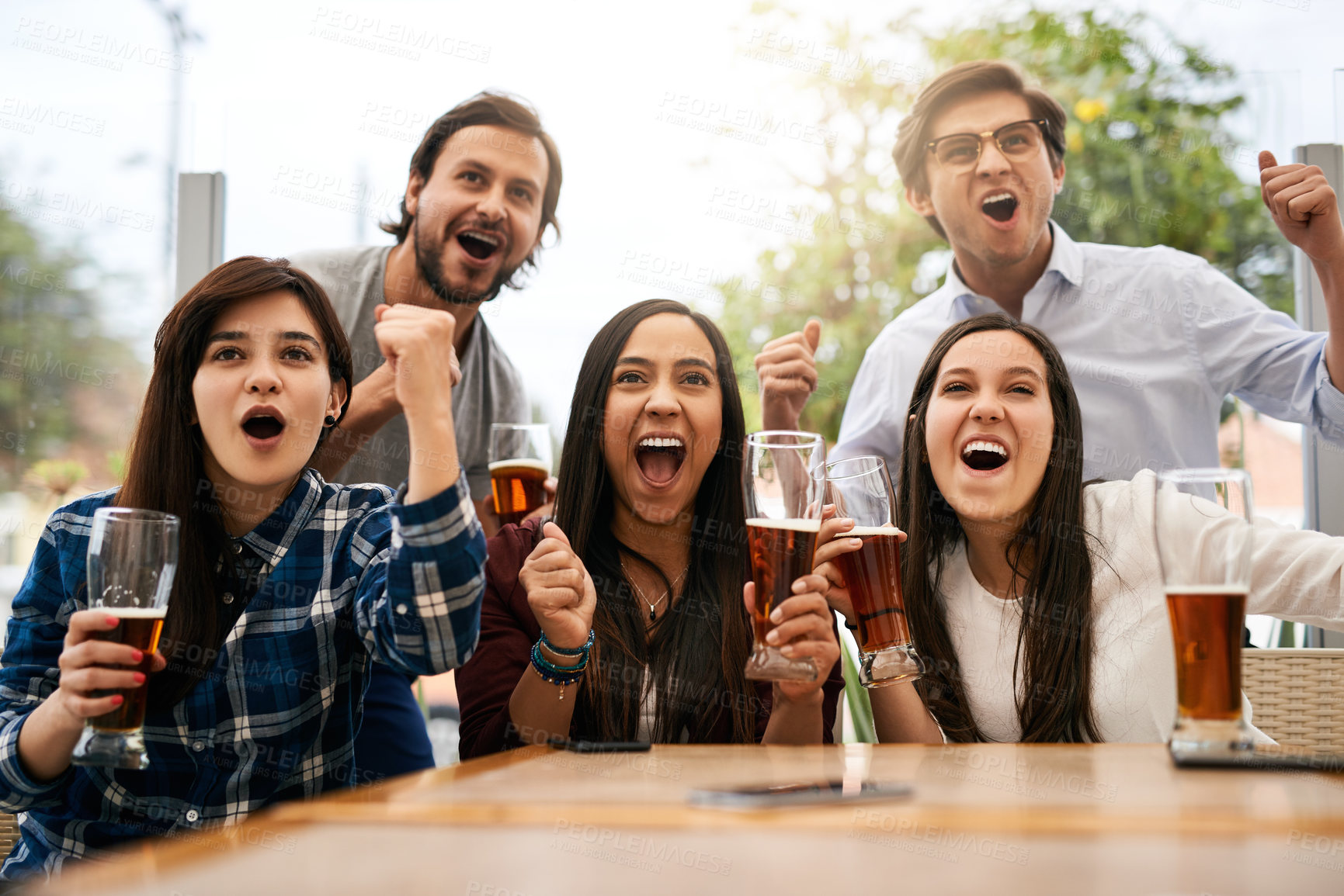 Buy stock photo Portrait of a cheerful young group of business work colleagues putting up their hands to celebrate at a restaurant