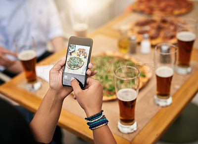 Buy stock photo Shot of a unrecognizable person taking a photo of a few pizzas on a table outside at a restaurant