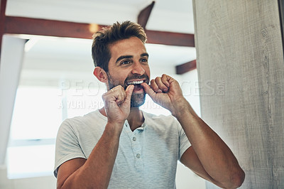 Buy stock photo Dental, floss and teeth with man in bathroom mirror for cleaning, morning routine and oral hygiene. Smile, cosmetics and health with male person flossing at home for self care, breath and mouth 